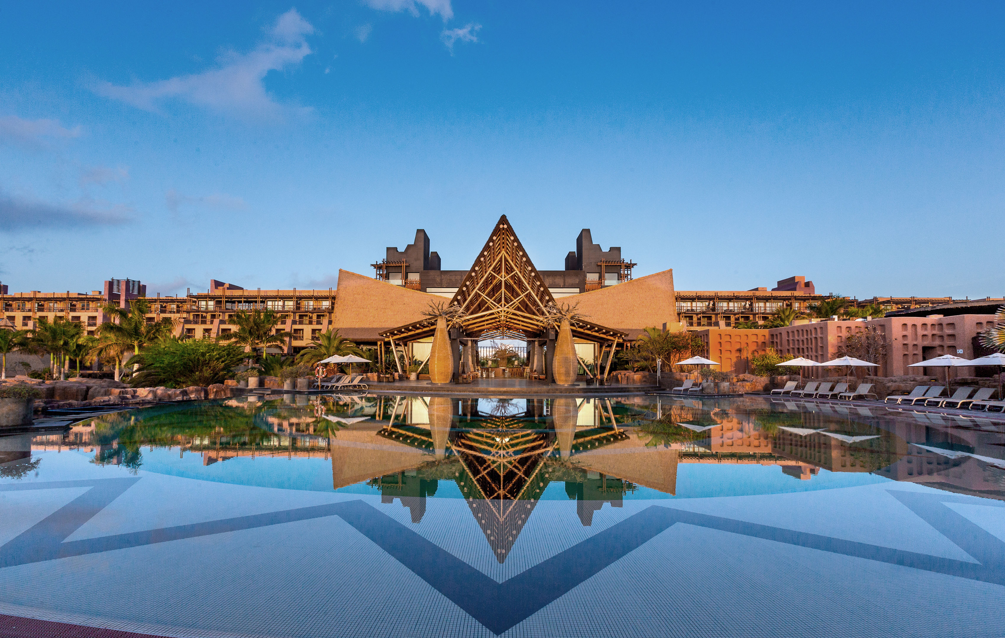 Luxe resort met zwembad en indrukwekkende architectuur bij zonsondergang